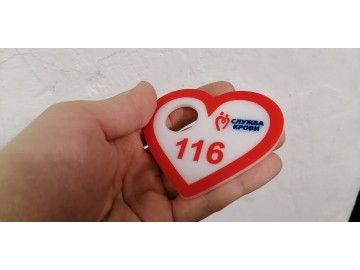 Номерок «Служба крови» в форме сердца № 116 в руке, фон — номерки для гардероба Уфа — НеоШтамп