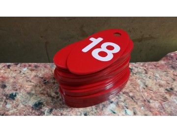 Стопка ярко-красных овальных номерков с белой цифрой «18» (без бренда) — номерки для гардероба Уфа — НеоШтамп